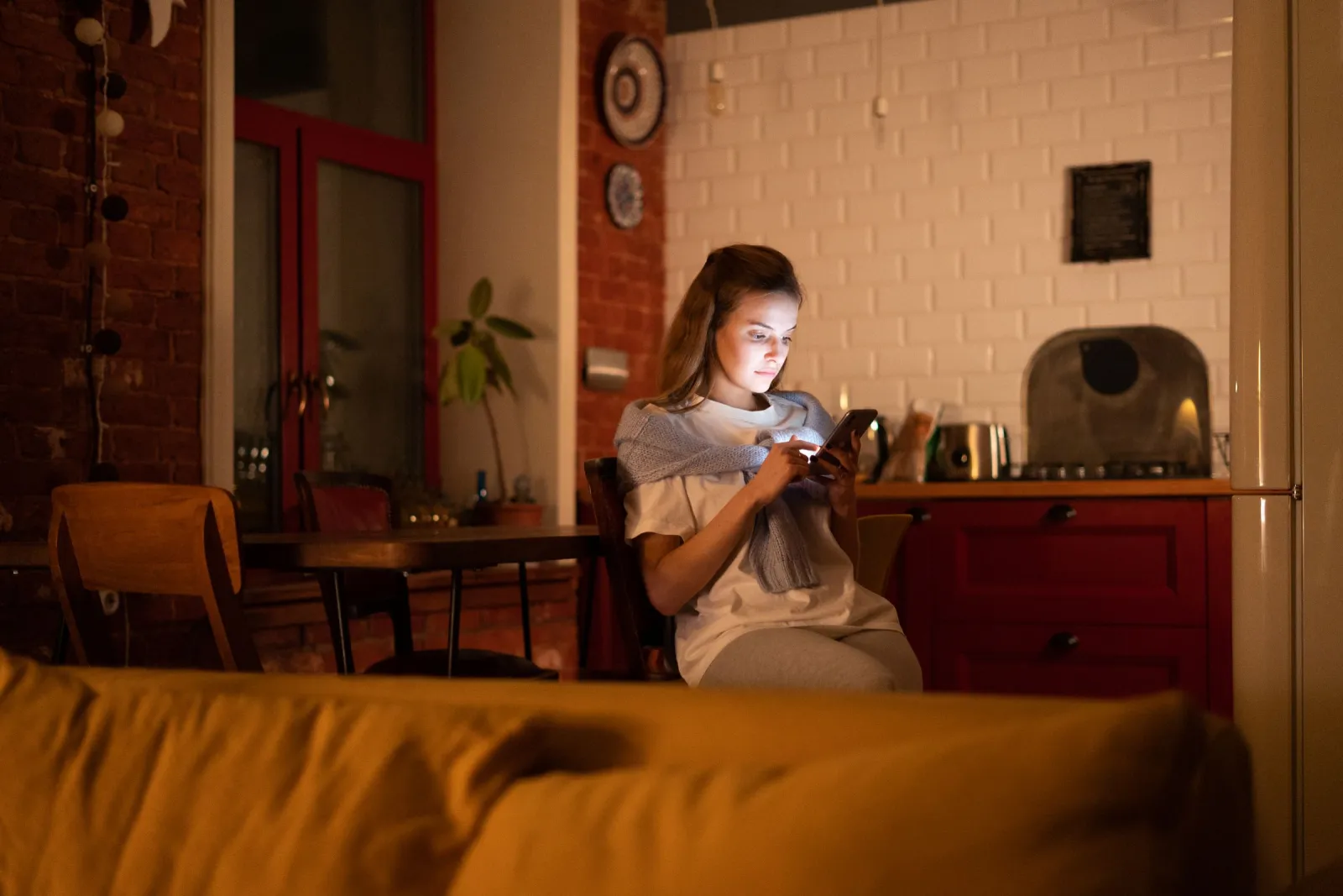 A person reviewing a smartphone at home in the evening